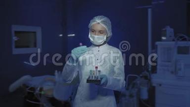 年轻女医生戴着医用面具看镜头的肖像。 医生手里拿着锥子
